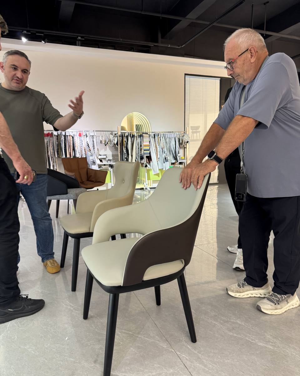 Trade visitors reviewing chair materials in the Mingyi showroom