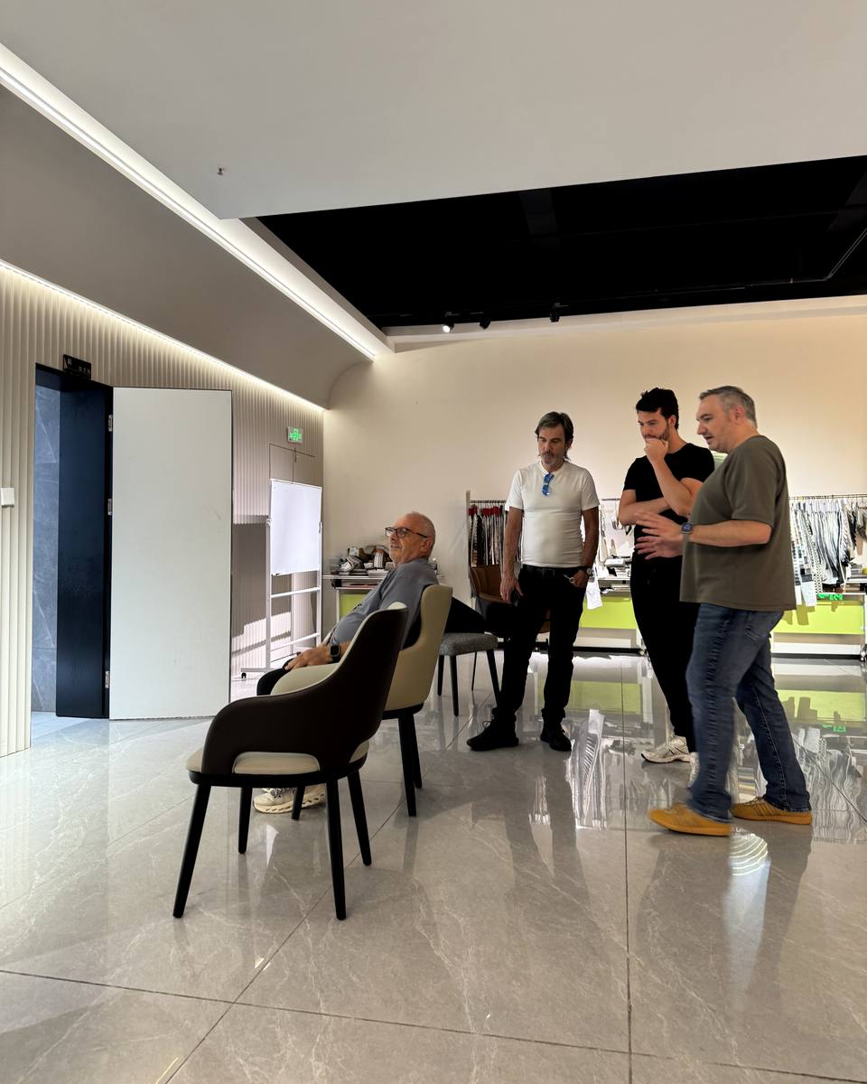Trade visitors testing upholstered chair comfort in the Mingyi showroom